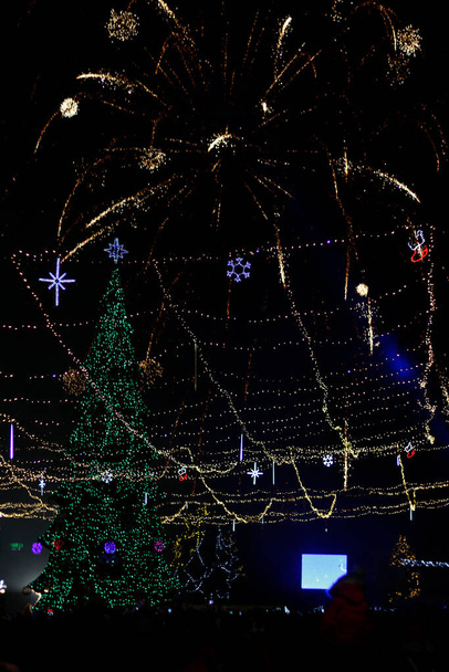 Nacht groeten in de stad aan de kerstboom om middernacht, wazig achtergrond - Foto, afbeelding