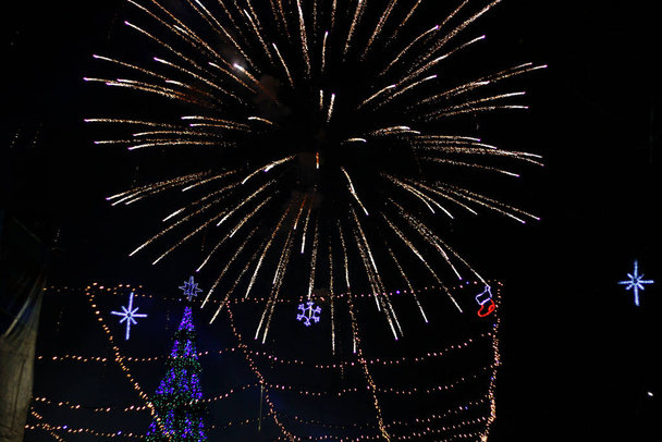 Nacht groeten in de stad aan de kerstboom om middernacht, wazig achtergrond - Foto, afbeelding