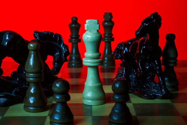 Witte koning omringd door wazige silhouetten van figuren - Foto, afbeelding