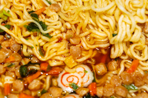 Cooked instant noodles with spices, dried vegetables and freeze-dried meat. Close up - Photo, Image