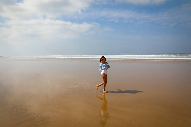 Meisje op het strand in badpak en hoed. De Atlantische Oceaan Agadir Marokko. - Foto, afbeelding