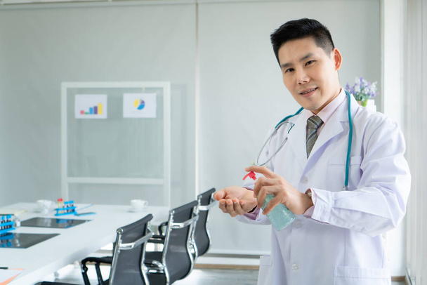 Kézmosó gél vagy fertőtlenítő Az orvos kezében egy ázsiai férfi orvos javasolja a módját, hogy mossa meg a kezét egy fertőtlenítő. A kórházi betegek gondozása - Fotó, kép