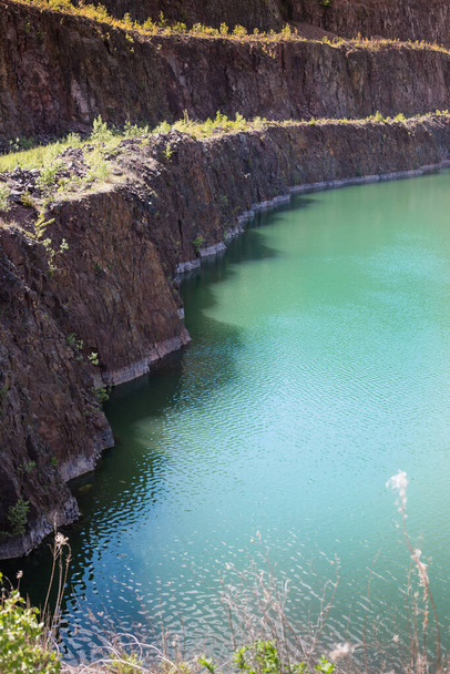 de wierki steengroeve, Polen. Een meer met kristalhelder turquoise water, een steile steengroeve helling, vissen zwemmen in het water - Foto, afbeelding