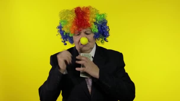 Clown-Unternehmerin mit Perücke hält einen Bock Geld Einkommen und verliert es - Filmmaterial, Video