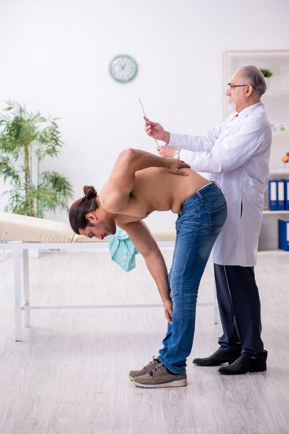 Junger Rückenverletzter zu Besuch bei erfahrenem Arzt - Foto, Bild