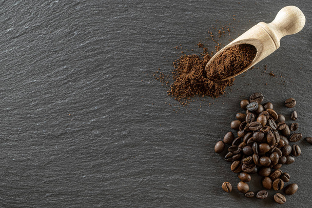 Cafe coffee background. Espresso beans for food, drink caffeine breakfast on black. Brown roasted coffee seeds isolated for energy mocha, cappuccino ingredient. Copy space, top view - Photo, Image