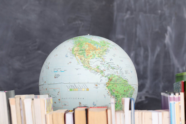 Geography lesson. A globe among a large number of school books. - Foto, immagini