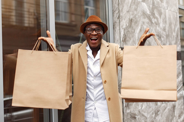Stylish black man in a city with shopping bags - Zdjęcie, obraz