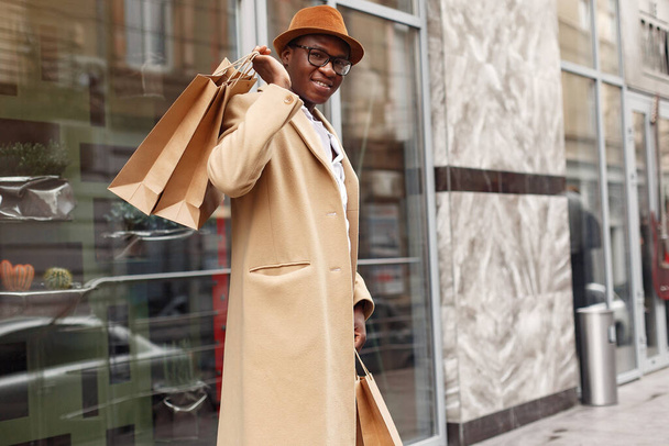 Stylish black man in a city with shopping bags - Foto, Imagen