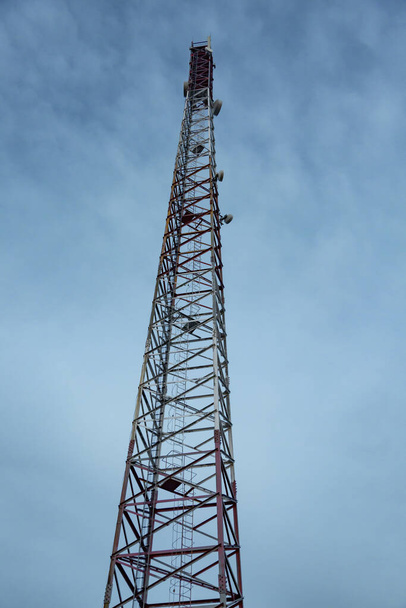 Cono en forma de metal móvil torre de comunicaciones sitio de la célula contra el cielo al atardecer. Orientación vertical
.  - Foto, imagen