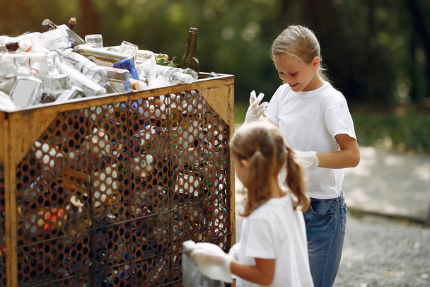 Children collects garbage in garbage bags in park - Foto, imagen