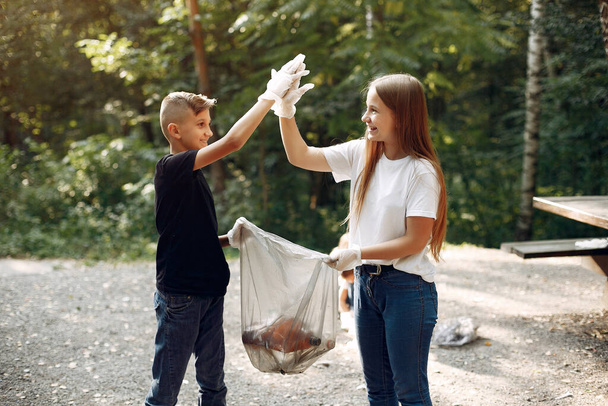 Children collects garbage in garbage bags in park - Foto, Imagen