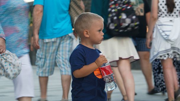 Lindo niño con el pelo rubio en camiseta azul en el terraplén en Crimea en las vacaciones de verano
 - Foto, imagen