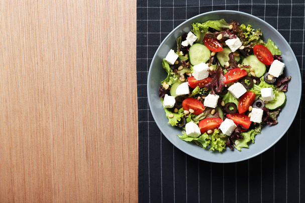 Tányér ízletes görög salátával az asztalon. A szöveg helye - Fotó, kép