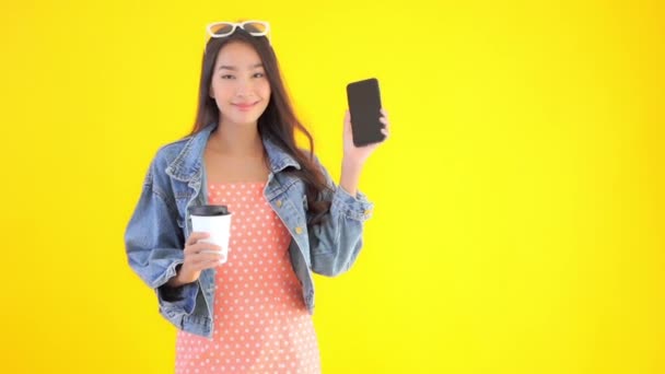 footage of beautiful asian woman with paper cup of coffee and smartphone - Felvétel, videó