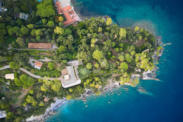 Una vista de arriba en la orilla del mar con árboles verdes y casas con villas. Las piedras enormes en el fondo del mar de Liguria, Italia
 - Foto, Imagen