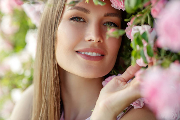 Beautiful woman in roses on the nature. - Foto, Imagem