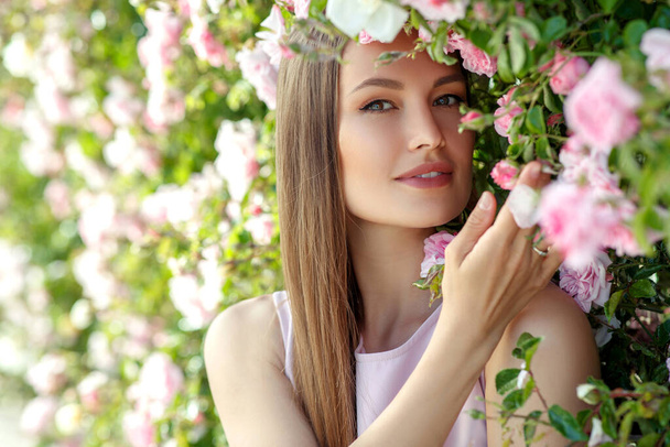 Όμορφη γυναίκα με τριαντάφυλλα στη φύση. - Φωτογραφία, εικόνα