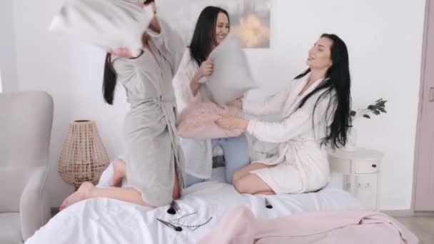 Beautiful women friends are playing with pillows in bed - Materiaali, video