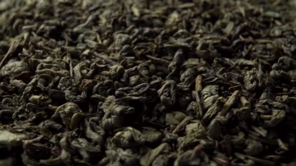 Green Chinese tea gunpowder. Dried coiled leaves close up. Rotation. Macro video. Selective focus - Materiaali, video