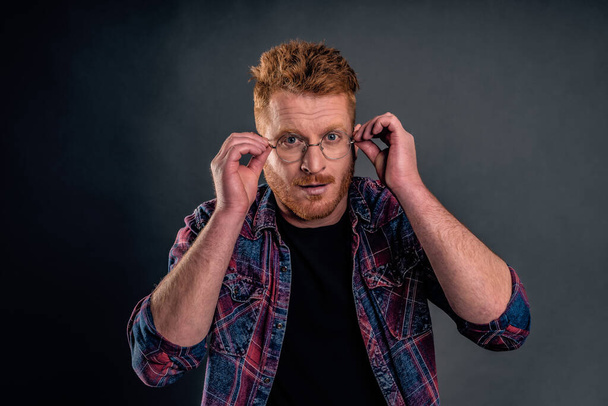 Let us get to business. Portrait of good-looking confident redhead mature guy with bristle in round glasses, holding hands on eyewear seriously, looking after employees in office - Photo, Image