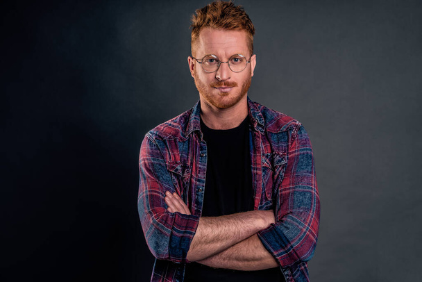 Let us get to business. Portrait of good-looking confident redhead mature guy with bristle in round glasses, holding hands on chest and smiling broadly, looking after employees in office - Фото, изображение