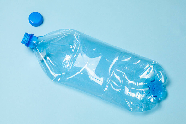 Mavi arka planda buruşmuş plastik şişeler. Plastik çöp. - Fotoğraf, Görsel