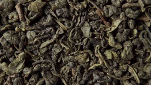 Puskapor Zöld kínai tea közelkép. Szárított hajtogatott levelek. Forgás. Makrofelvétel - Felvétel, videó