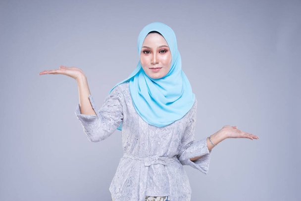 Beau modèle féminin dans diverses poses portant kebaya moderne et hijab, un vêtement de style de vie urbain pour les femmes musulmanes isolées sur fond gris. Concept de mode beauté et hijab. Demi longueur
. - Photo, image
