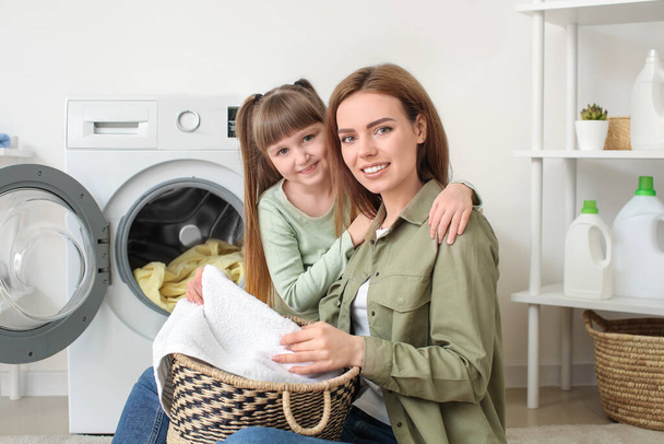 Kobieta i jej słodkie córeczka robi pranie w domu - Zdjęcie, obraz