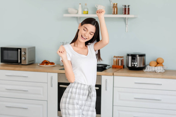 美しい若い女性が台所で踊る - 写真・画像