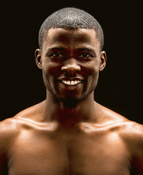Nude African American man sexy smiling on black background. Front view of handsome macho. Toned image - Foto, imagen