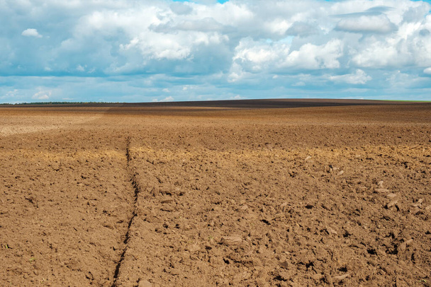 a plowed field with cloud shadows. preparation of farm land in the winter - Photo, Image