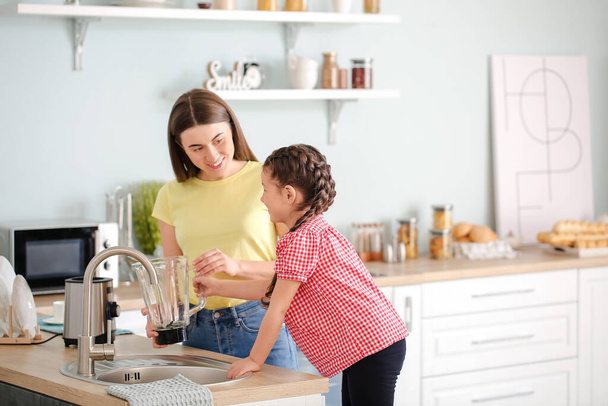 Mother and little daughter cleaning blender in kitchen - Photo, Image