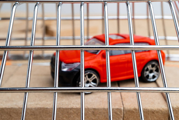 Červené autíčko je pokryto mřížemi. auto zatčeno za dluhy - Fotografie, Obrázek