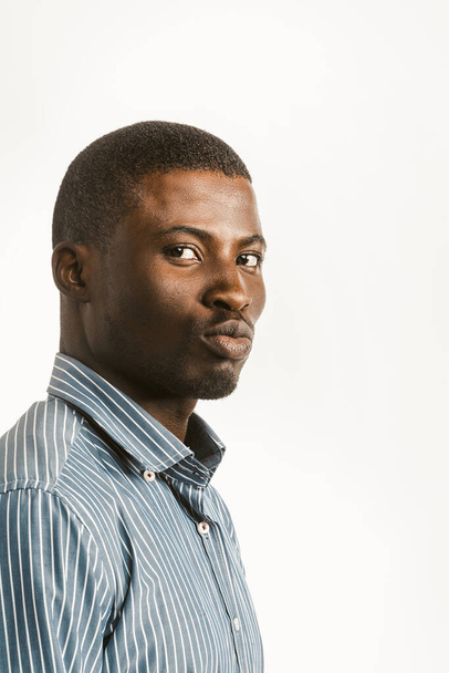Charming dark-skinned guy makes duck lips looking at camera. Young African American handsome man isolated on white background. Textspace at right side. Toned image - Zdjęcie, obraz