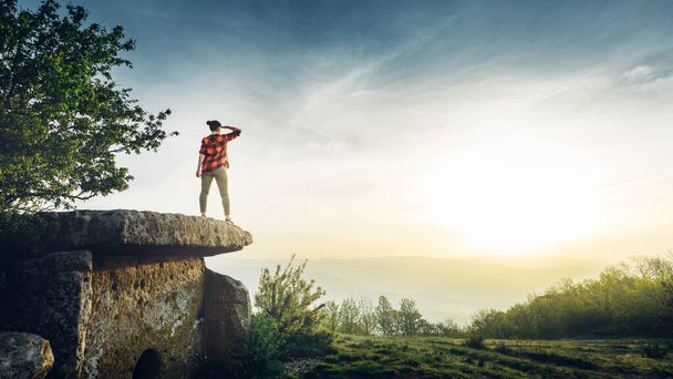 Woman Traveler Stands On Ancient Megalith And Looks Into Distance. Scout Travel Adventure Concep - Fotoğraf, Görsel