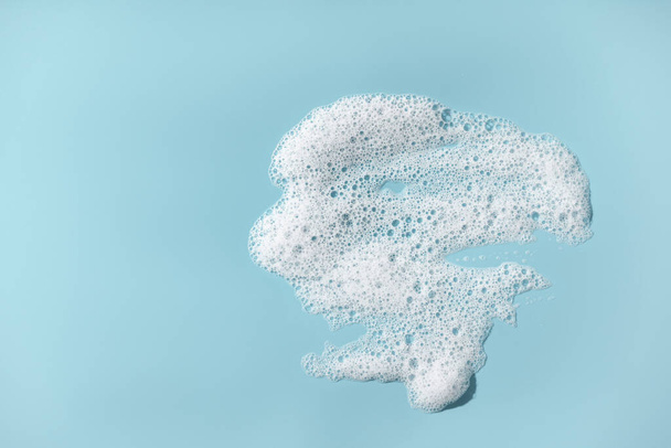 Foam with bubbles. Soap sud on blue background. - Fotó, kép
