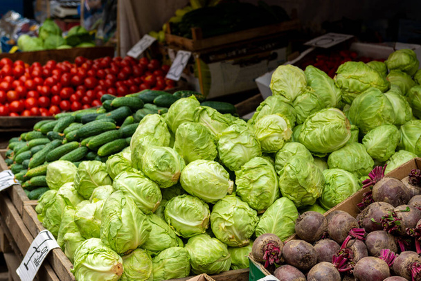 Grüne Gurken und Kohl. Reifes Gemüse am Marktfenster. Wiederaufnahme der Märkte in Städten nach Quarantäne 2021. - Foto, Bild