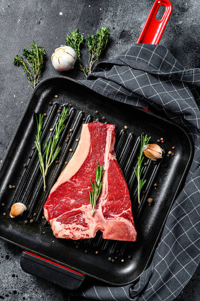 T bone steak in a pan. Organic raw Tbon beef. Black background. Top view - Фото, зображення