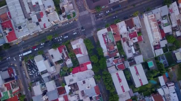 Drone πάνω από μια λεωφόρο σε ένα προάστιο της πόλης του Μπουένος Άιρες με σπίτια και κτίρια γύρω - Πλάνα, βίντεο