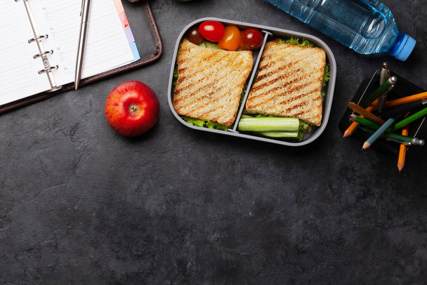 Υγιεινό κουτί φαγητού με σάντουιτς και λαχανικά στο τραπέζι του γραφείου. Κάτοψη με χώρο αντιγραφής. Επίπεδη - Φωτογραφία, εικόνα