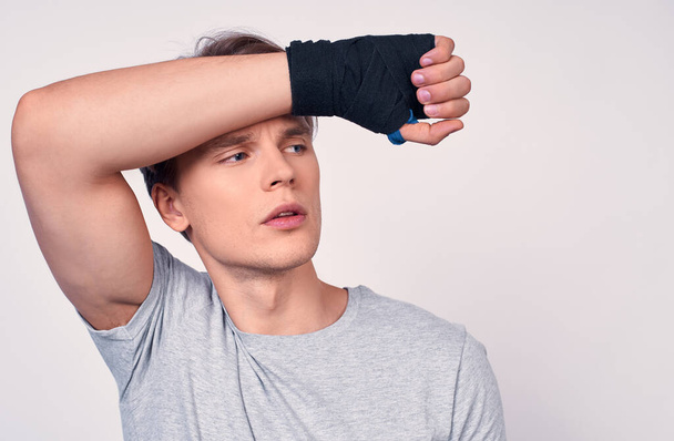 Tired young lovely fitness sporty tired in headband t-shirt spend the weekend in home gym isolated on white background. Training sports motivation concept. Boxing with sports bandages on his hands. - 写真・画像