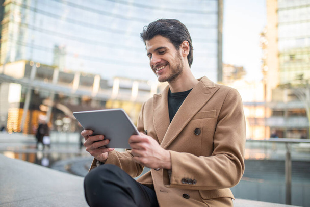 Young man using his tablet outdoor in a city - Photo, Image