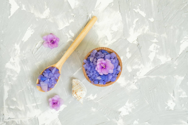 Wooden spoon and bowl with purple sea salt on grey background.Background for advertising salty. - Φωτογραφία, εικόνα
