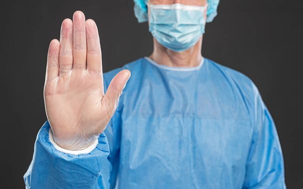 Doctor in protective uniform showing stop gesture - Foto, imagen
