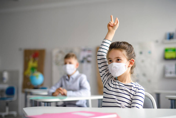 Child with face mask back at school after covid-19 quarantine and lockdown. - Φωτογραφία, εικόνα