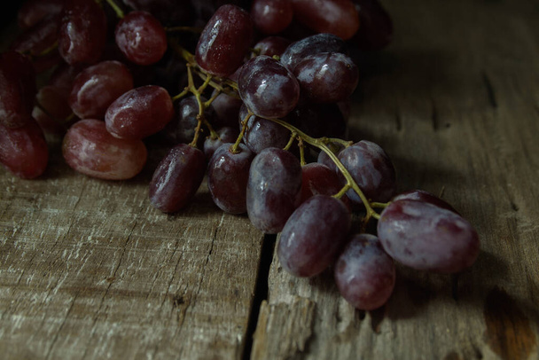 Low Key Photo Freshness Fruit Purple Grapes Closeup on Wooden Background - Photo, Image