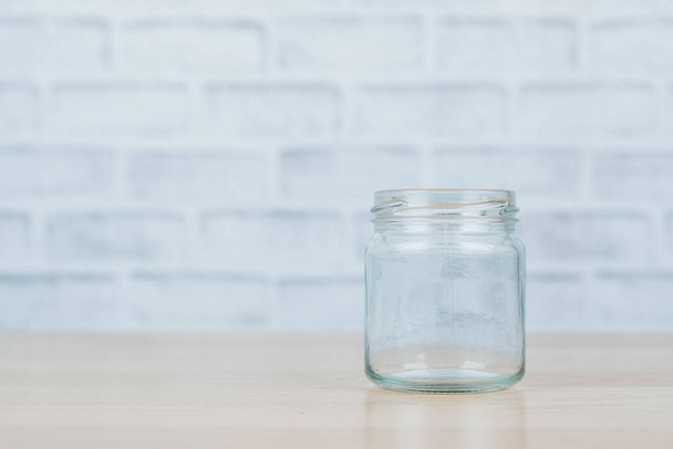 Glass jar on wooden desk. - Fotó, kép
