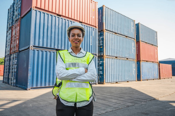 Zwarte voorman vrouwelijke werknemer werken controleren in Container cargo haven aan het laden van containers. Afrikaanse dock vrouwelijk personeel bedrijf Logistiek import export scheepvaart concept. - Foto, afbeelding